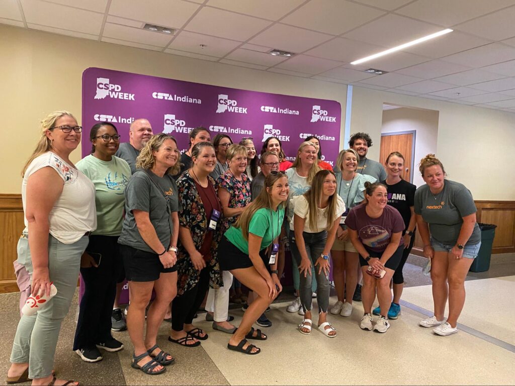 A group of teachers post in front of a purple background with the CSTA Indiana logo 